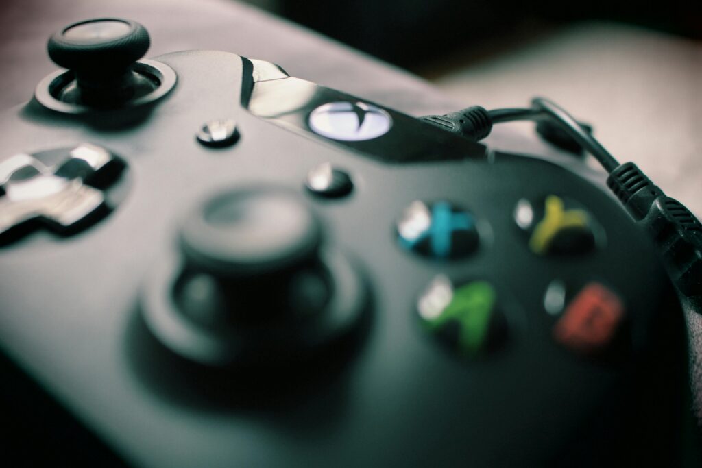 Detailed view of a black gaming controller showcasing its sleek design and colorful buttons.