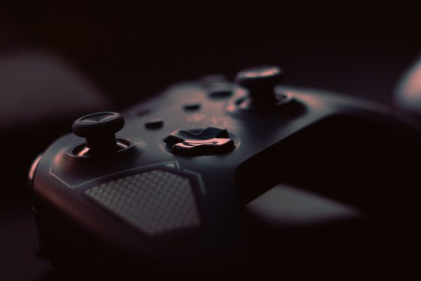 A close-up shot of a game controller in low light, highlighting its design and buttons.