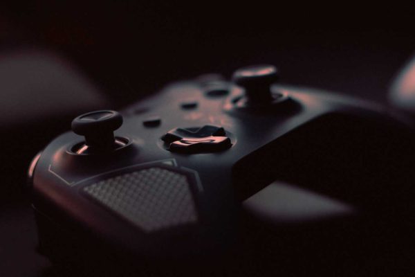 A close-up shot of a game controller in low light, highlighting its design and buttons.