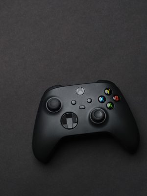 Black gaming controller on a dark backdrop, perfect for tech and gaming themes.