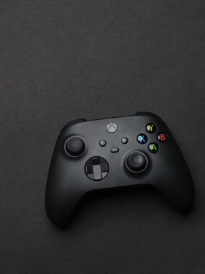 Black gaming controller on a dark backdrop, perfect for tech and gaming themes.