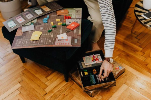Close-up of a strategic board game with colorful pieces in a cozy indoor space.