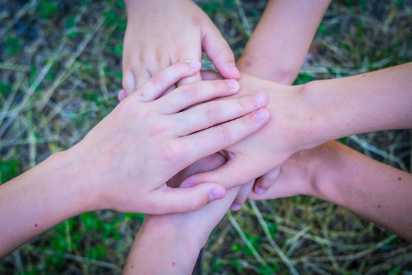 Close-up of diverse hands stacked together as a symbol of unity and teamwork.